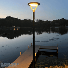 A Solera SL-CPT-25L Series Solar Powered Post Top Light Installed On A Post Beside A Dock At A Cottage. The Model Shown Is The 3000K Model. Commercial Solar Lighting From LED Network.